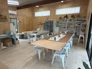 Workbenches and shelves of pottery inside the timber-lined studio