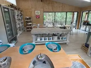 Glazed bowls on the bench with the studio and its windows behind